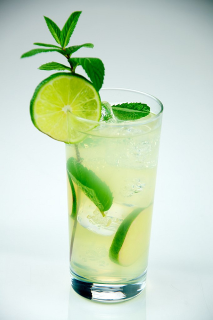 Mojito made with rum, lime, sugar, mint, club soda, served in a tall glass.