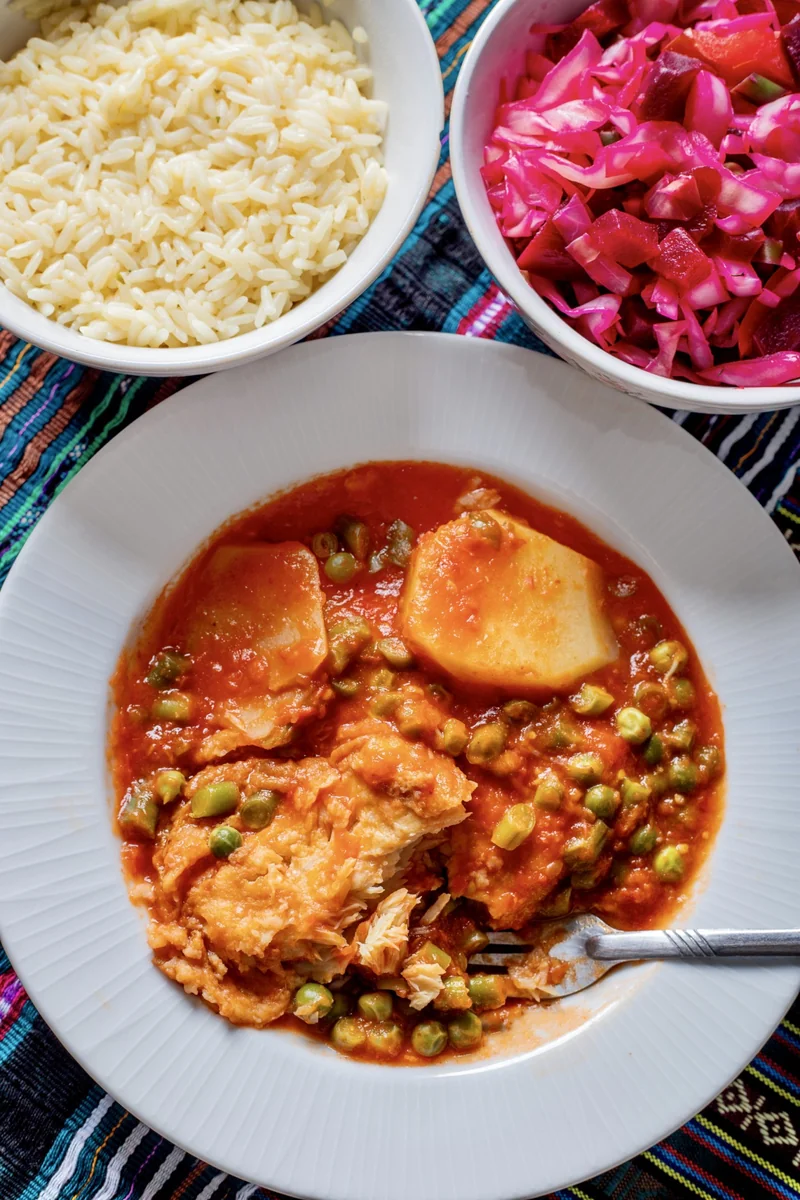 Guatemalan bacalao a la vizcaína with potatoes and peas, served with white rice and curtido