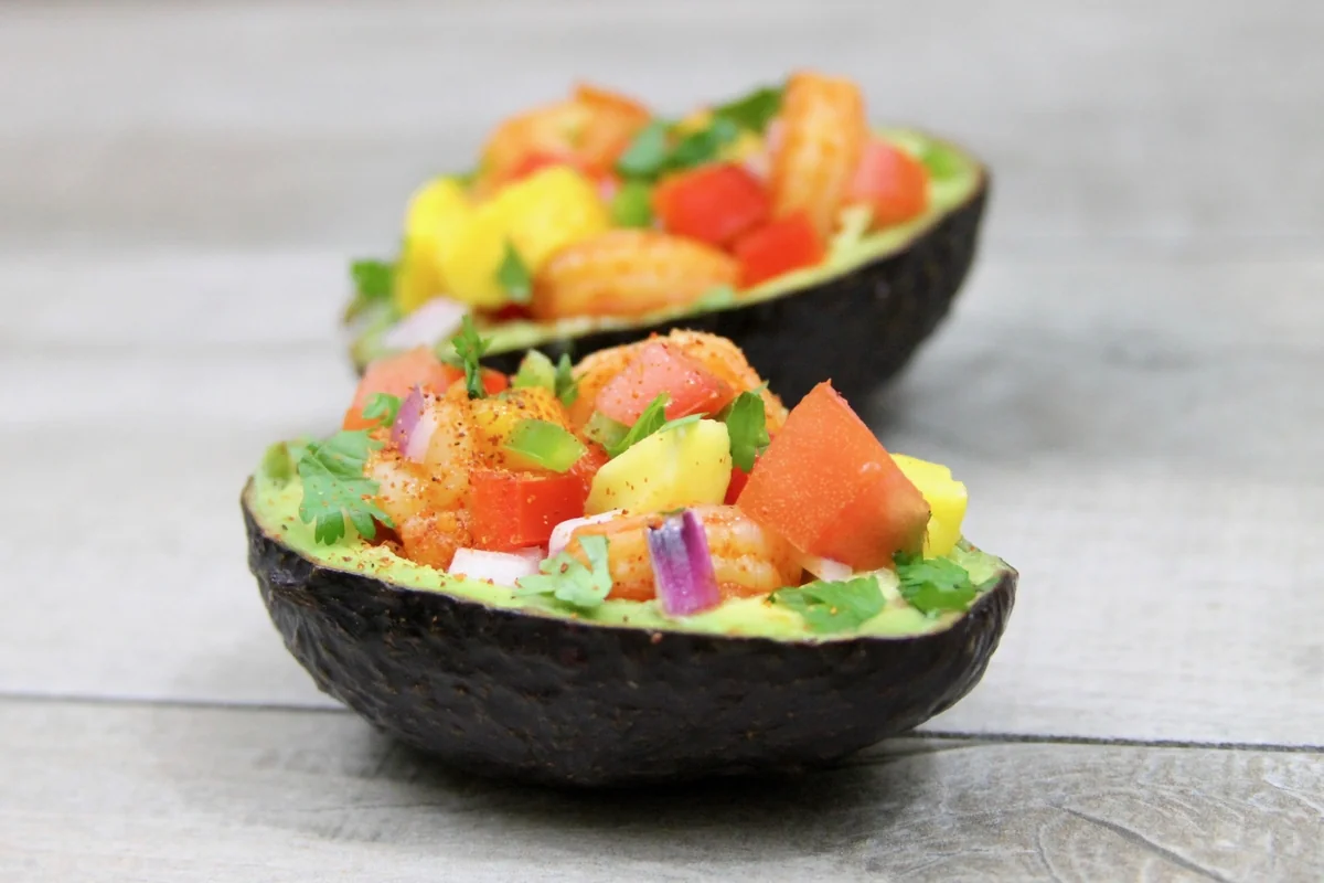 Shrimp and mango ceviche served inside avocado halves with tomato, red onion and cilantro