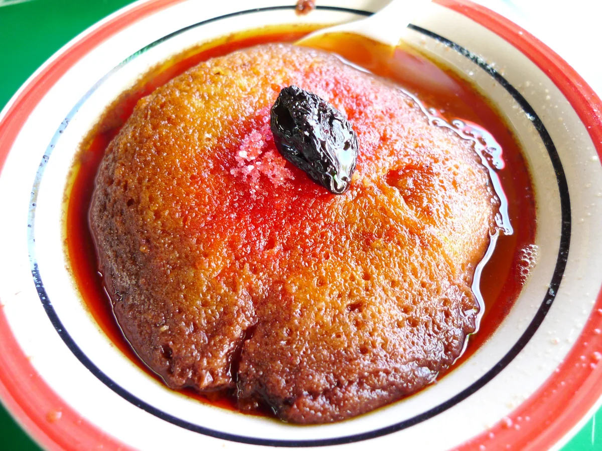 Close-up of a fried torreja glossy with red caramel sauce and sugar