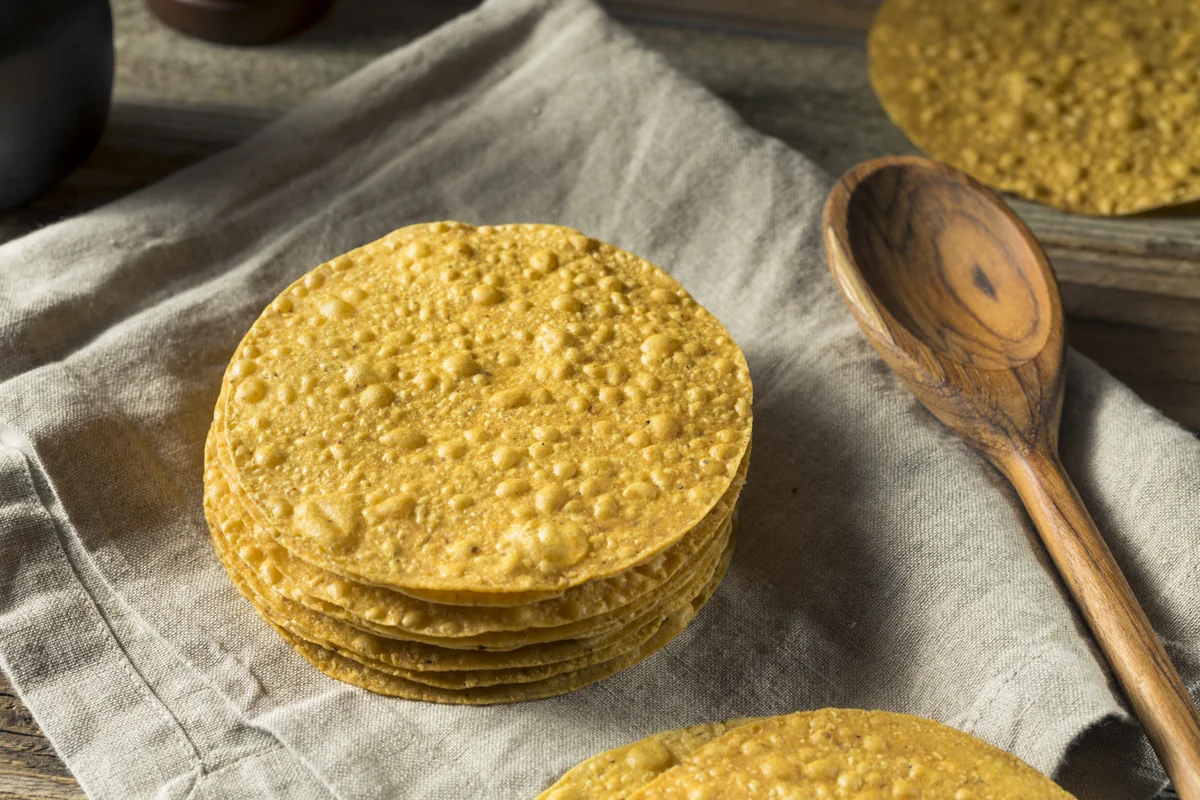 Stack of frieded corn tortillas on a linen cloth, the starting base before making Guatemalan tostadas