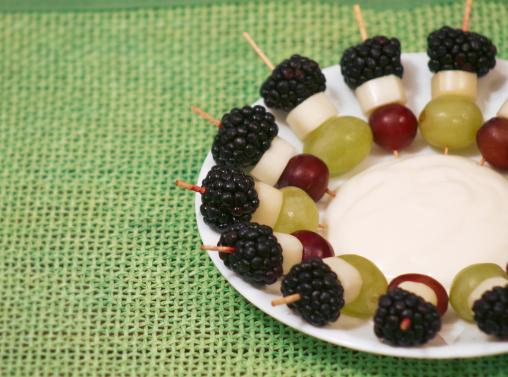 Mini fruit and cheese kabobs accompanied by yogurt for dipping. 