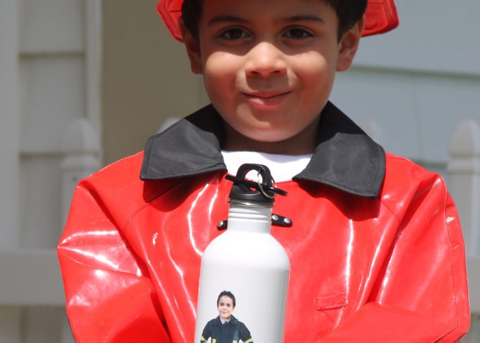 boy in firefighter costume holding Flattenme water bottle