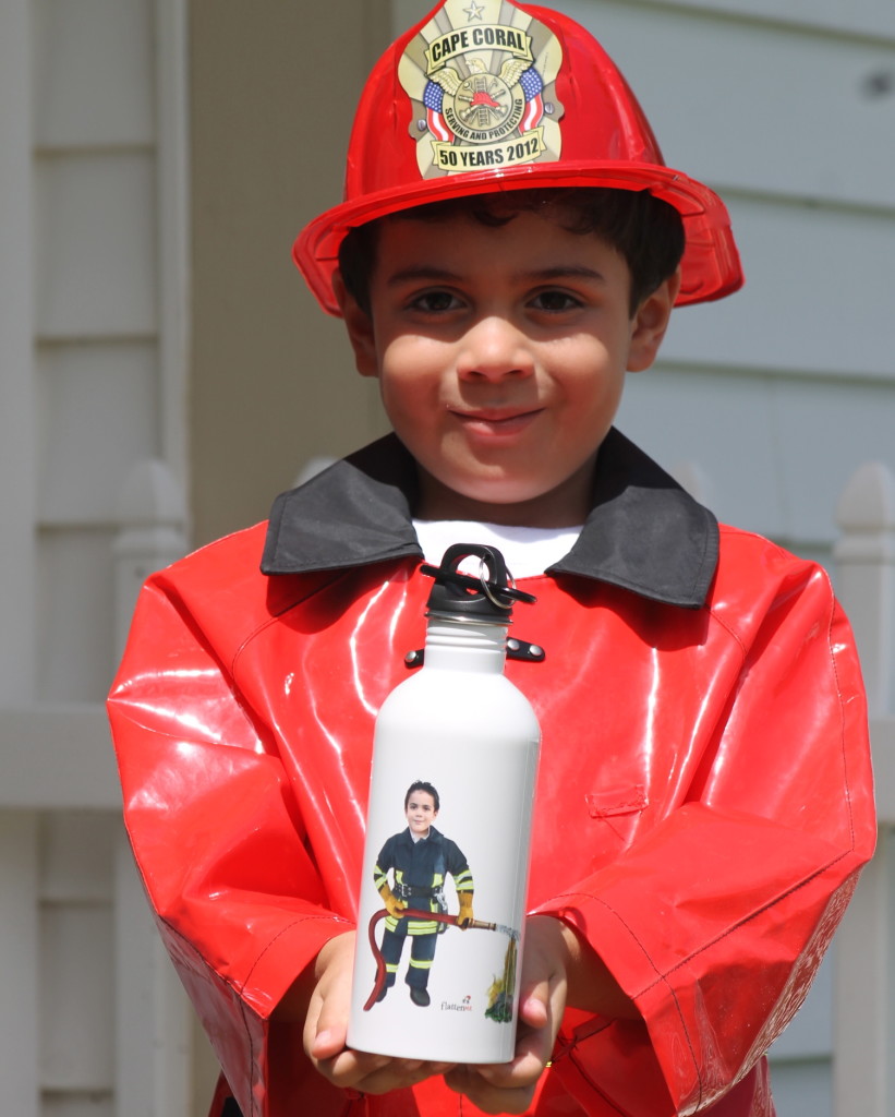 boy in firefighter costume holding Flattenme water bottle