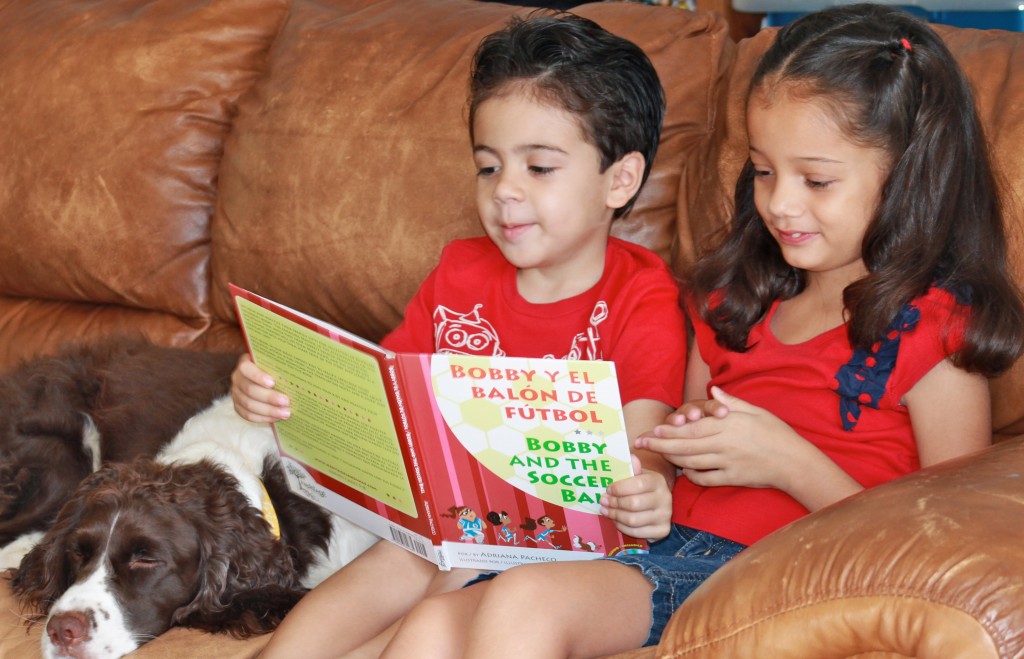 boy and girl reading book in spanish with dog