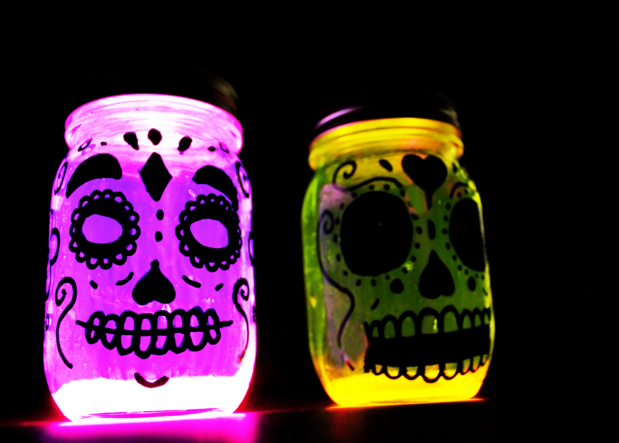 Glow in the dark Day of the Dead or Dia de los Muertos skull lanterns made with mason jars.