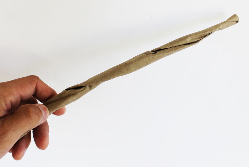 Twisting the paper to make it look like a stick.