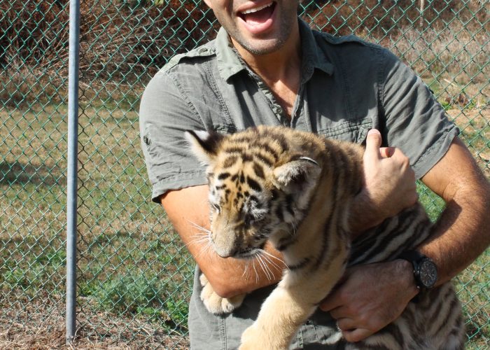 man carrying baby tiger