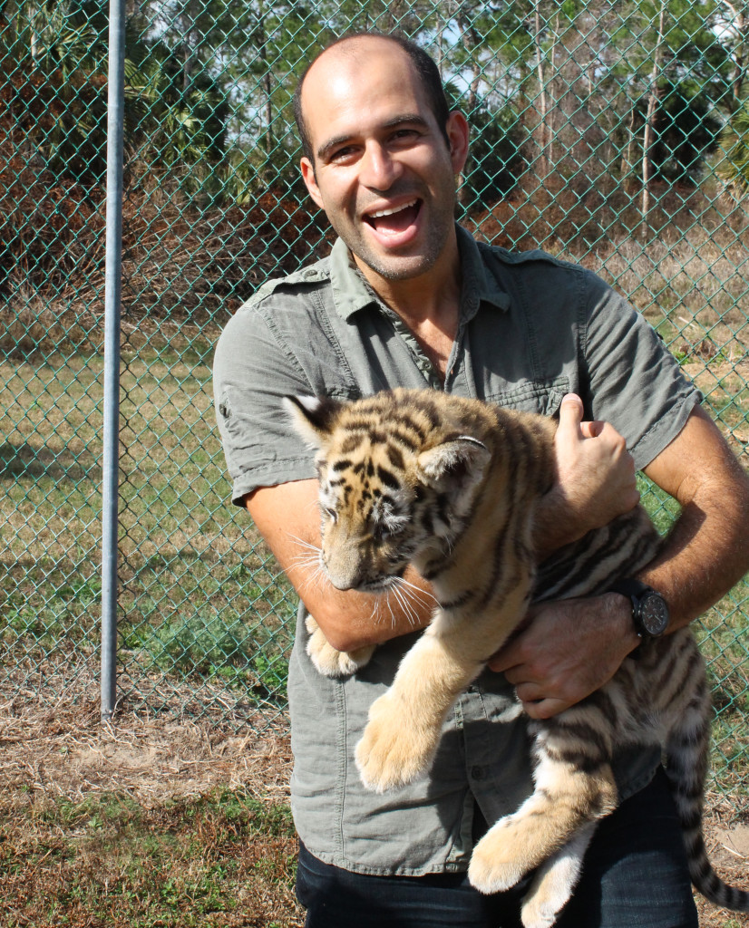 man carrying baby tiger