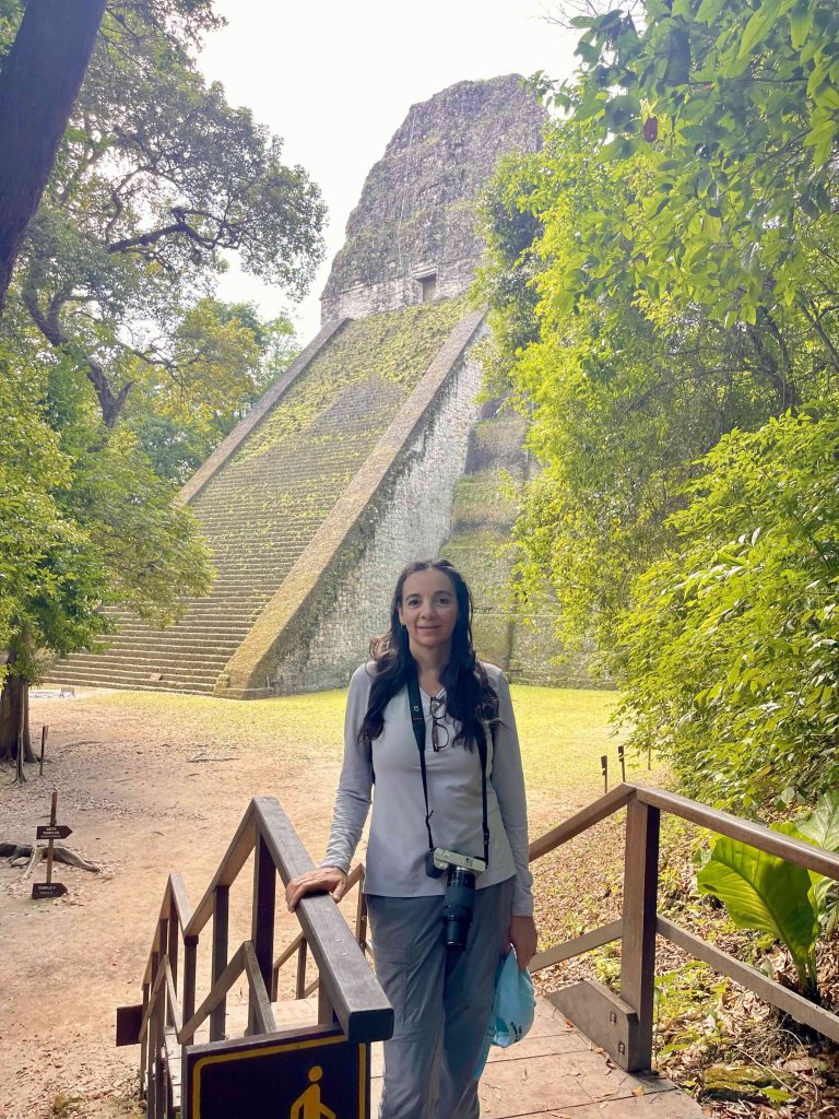 Latina travel blogger in front of a Maya temple at Tikal in Guatemala while building a travel blog into a business
