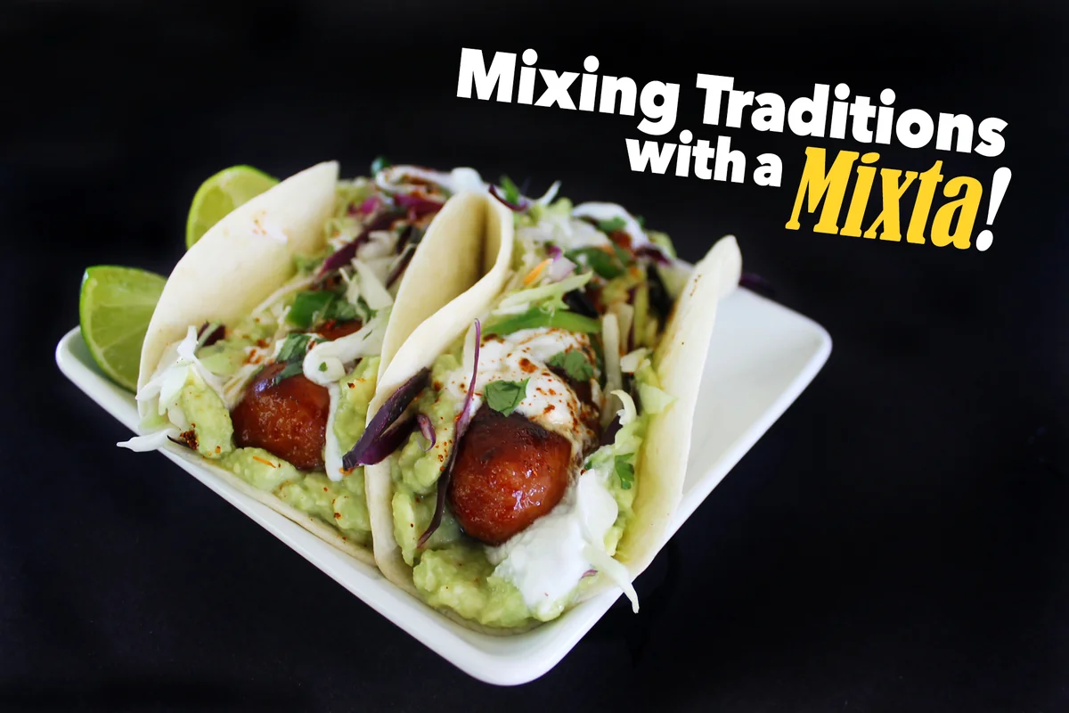 Two Guatemalan mixtas, hot dogs in soft corn tortillas with guacamol, cabbage, and crema, with lime