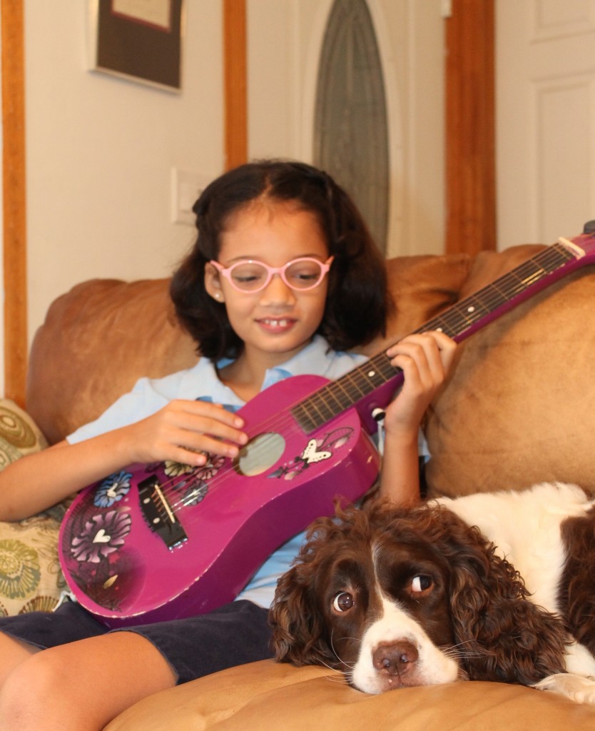 girl playing guitar with dog