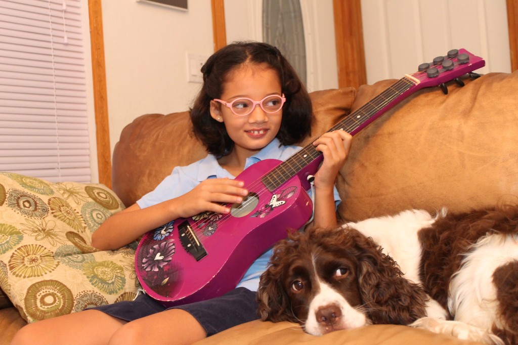 girl playing guitar with dog