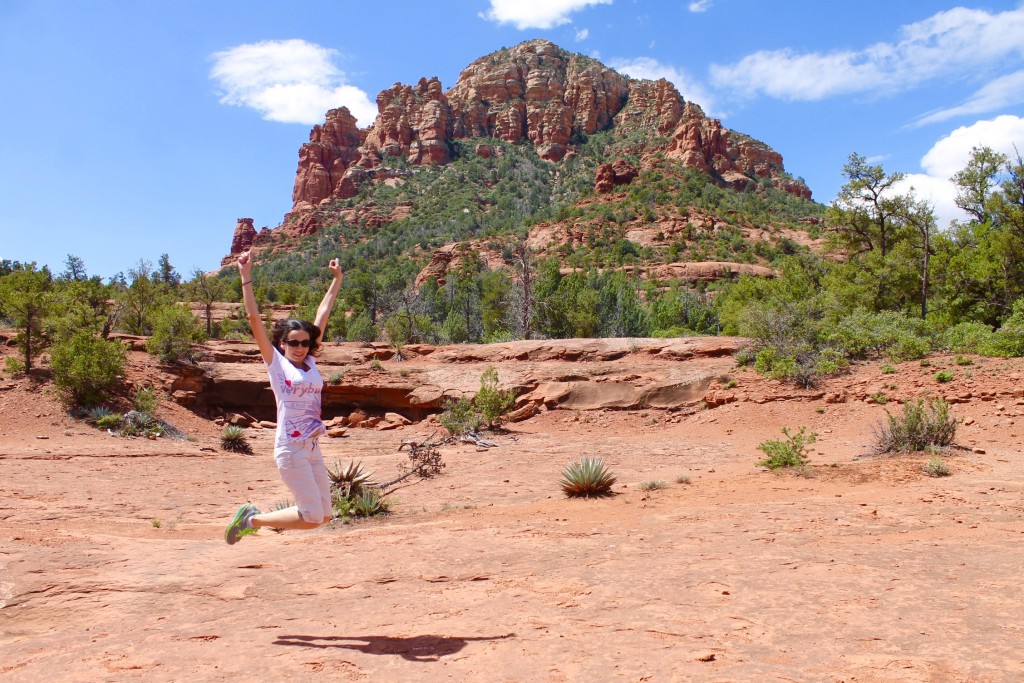 Woman jumping in front of red rocks in Sedona