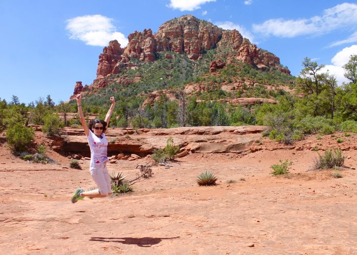 Woman jumping in front of red rocks in Sedona