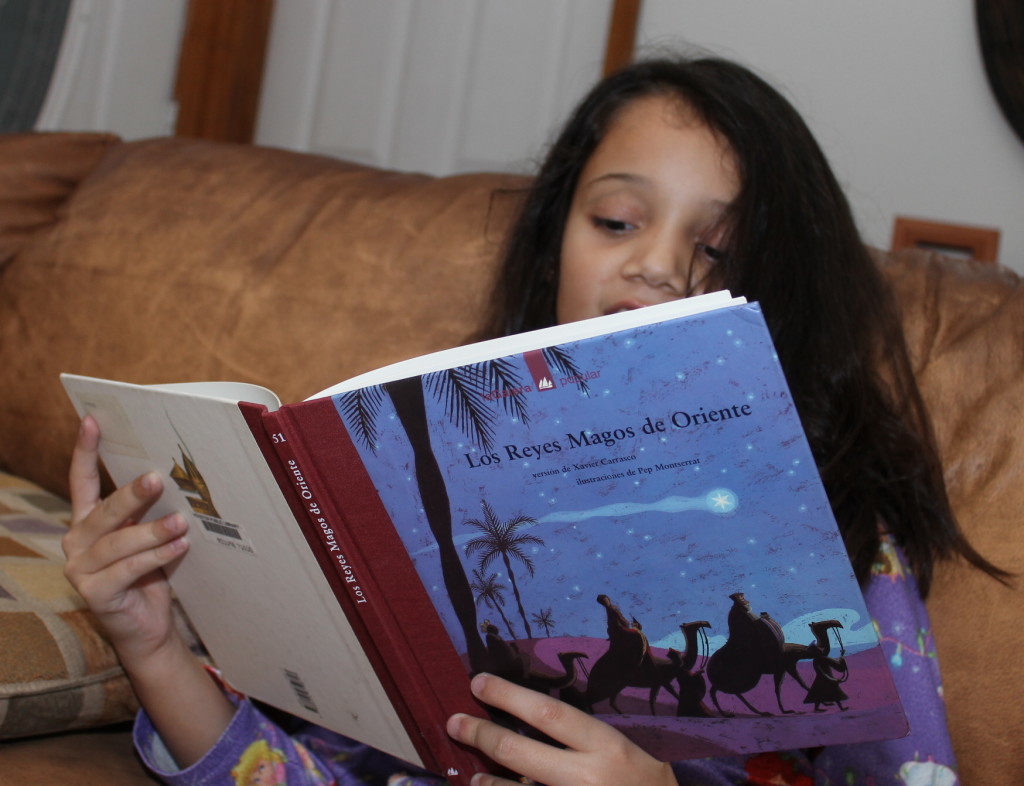 Girl reading a Dia de Reyes book