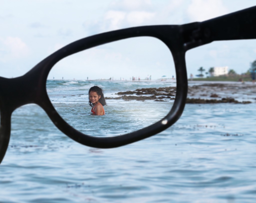 beach and girl seen through eyeglasses