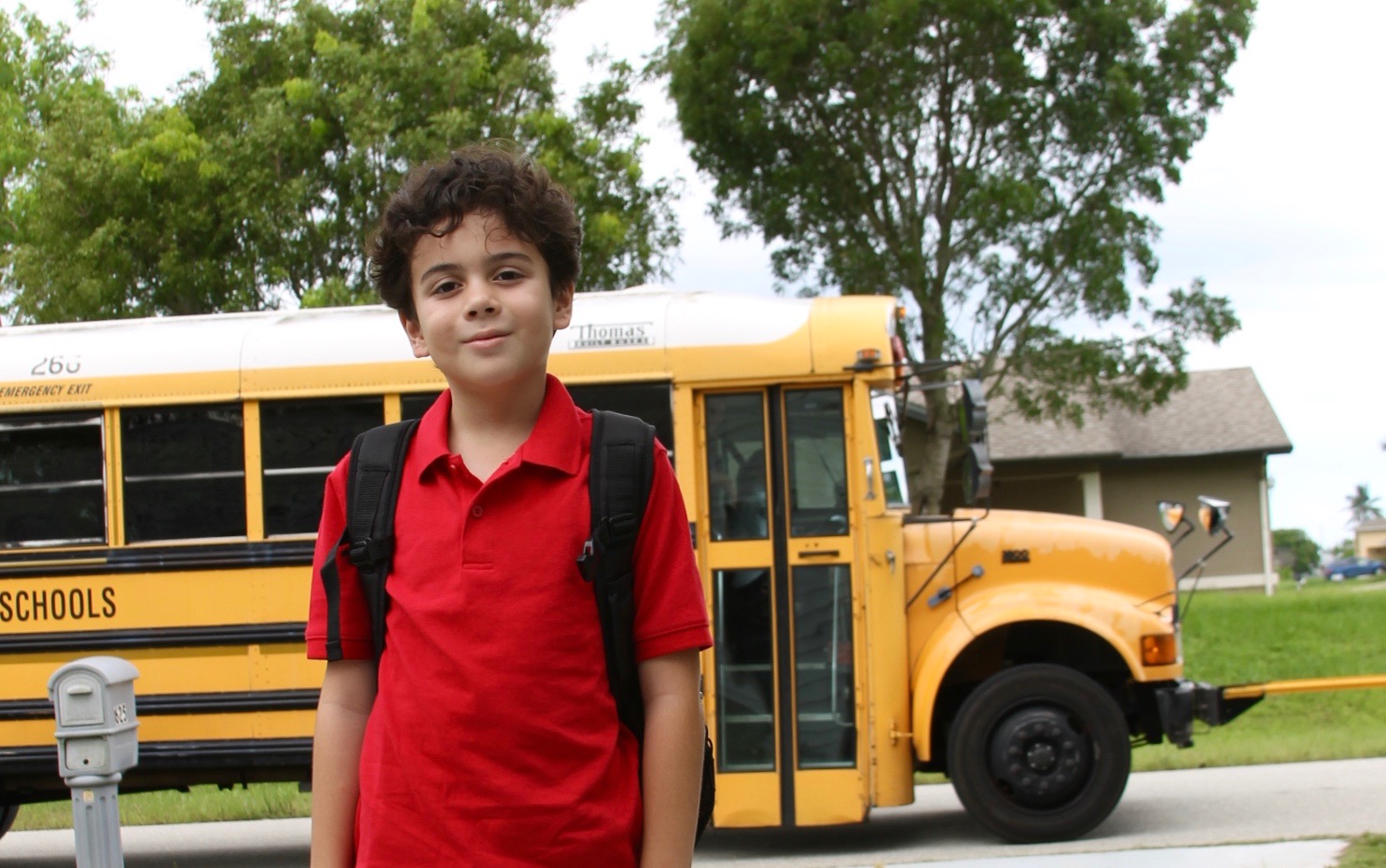 Latino boy in front of bus