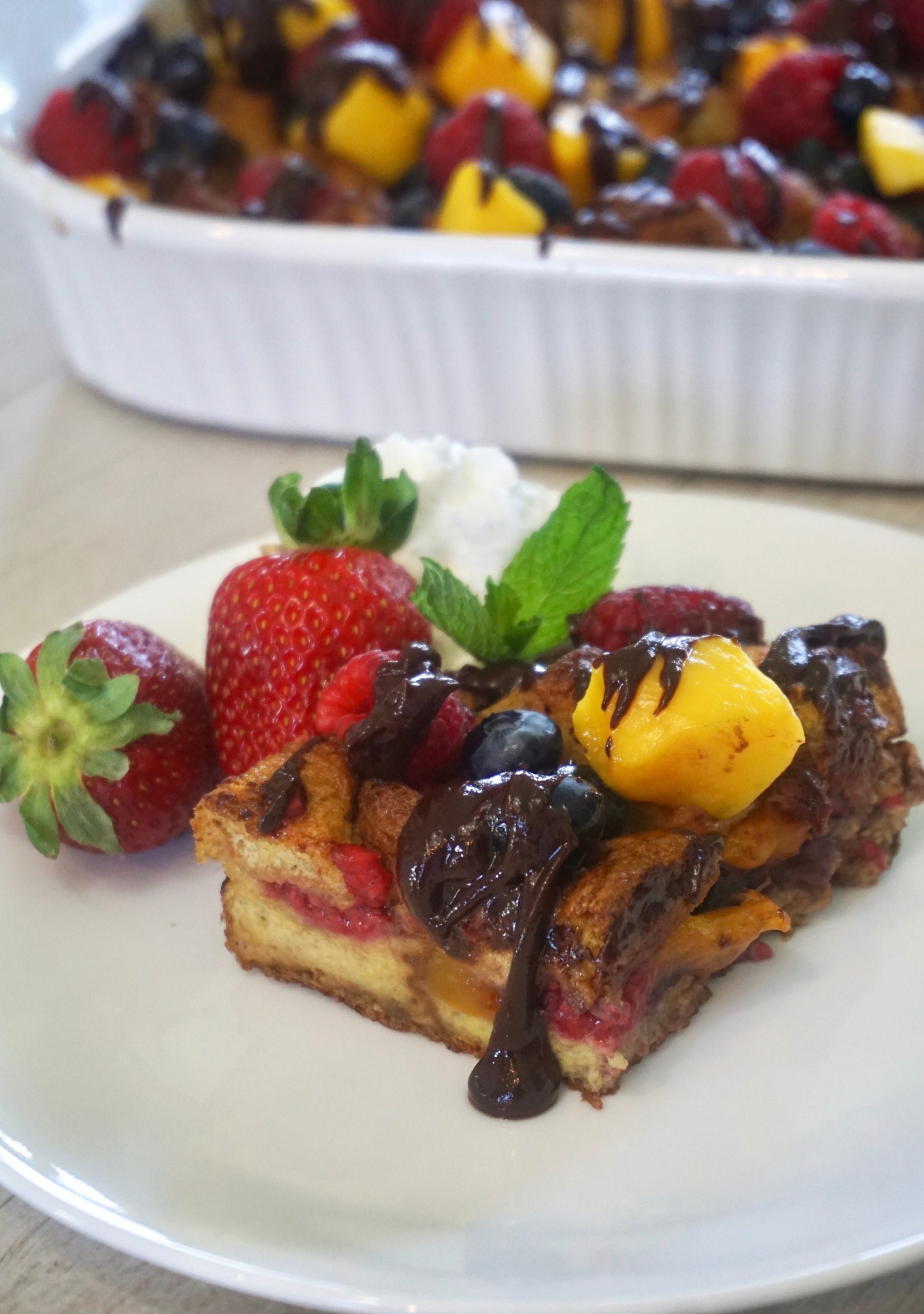 Easy berries and mango french toast casserole with chocolate drizzle