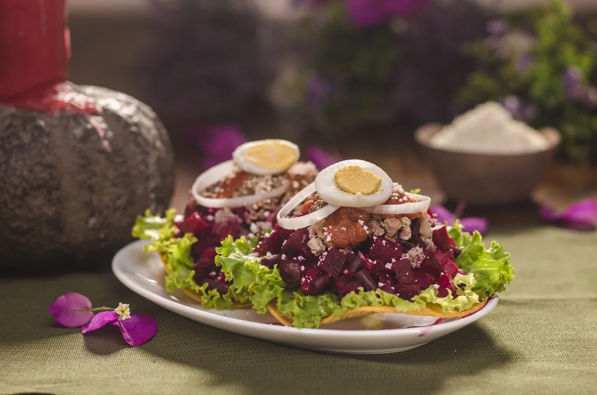 Guatemalan enchiladas, crispy tostadas topped with beet salad, meat, egg and onion