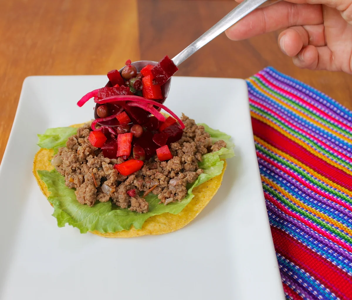 Enchiladas guatemaltecas jardineras con curtido, carne y queso seco