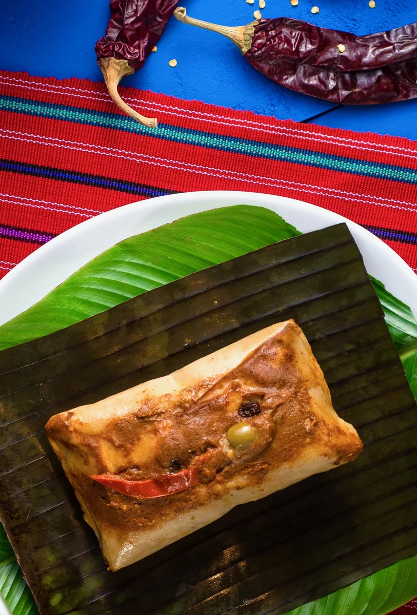 Tamales colorados guatemaltecos en hoja de plátano con recado