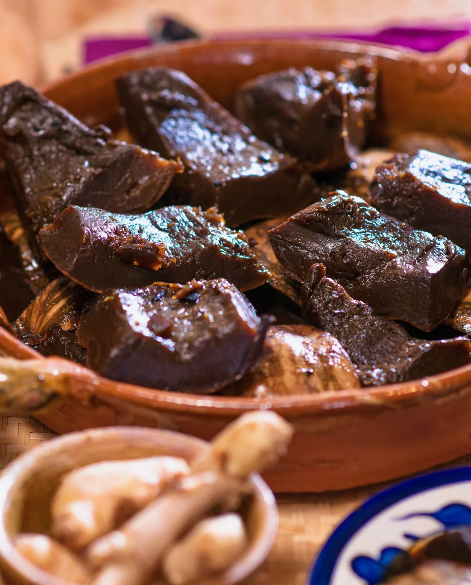 Close-up of candied ayote pieces glossy with dark panela syrup