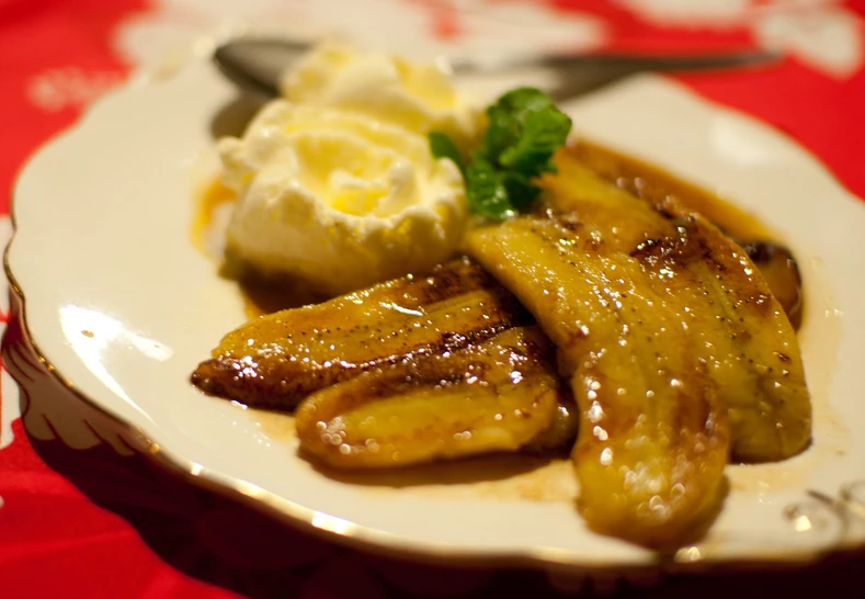 Bananas with sweet cream, caramelized banana halves topped with whipped cream and mint