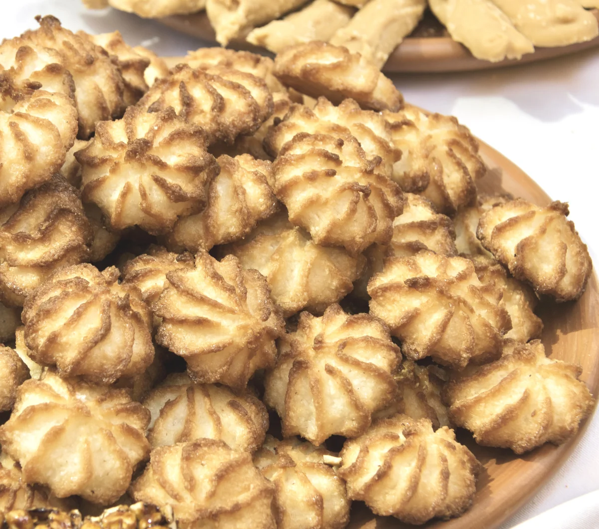 Guatemalan cocadas, piped coconut cookies baked golden at the edges, on a wooden plate