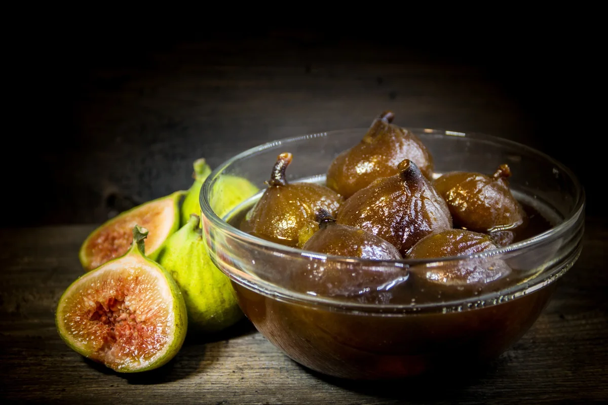 Higos en dulce, figs simmered in panela syrup, served in a glass bowl beside fresh figs