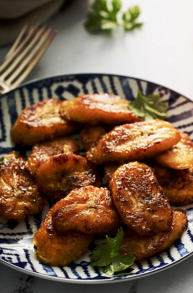 Platanitos fritos, postres guatemaltecos hechos con plátanos maduros dorados servidos en plato azul