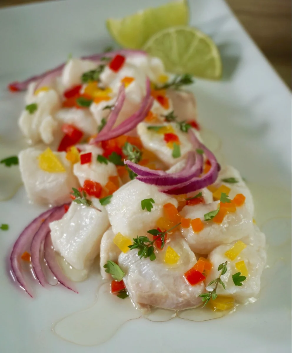 Peruvian fish ceviche plated with red onion, diced peppers, and cilantro