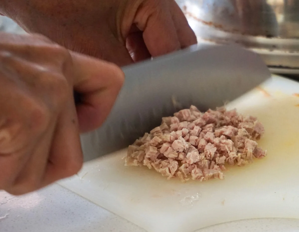 Picando finamente la carne cocida en una tabla para el salpicón de res