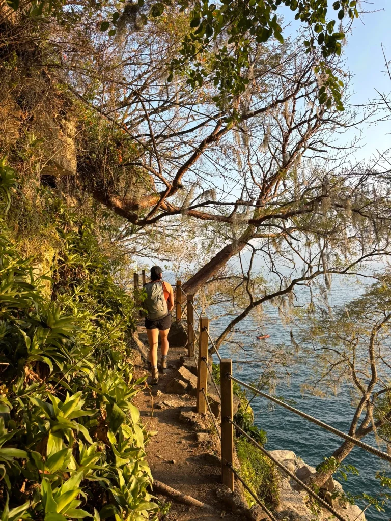 Hiker walking along the lakeside trail at Cerro Tzankujil Nature Reserve in San Marcos La Laguna Guatemala