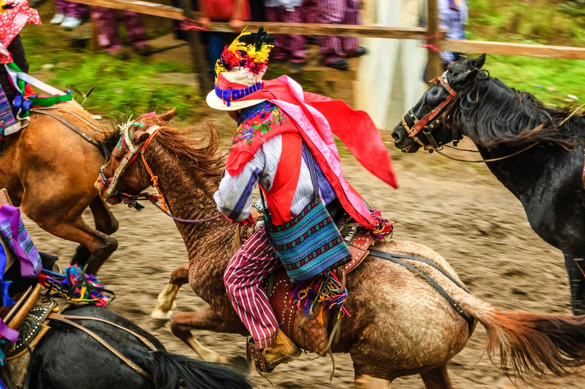 Riders in traditional red-and-white dress in the All Saints’ Day horse race