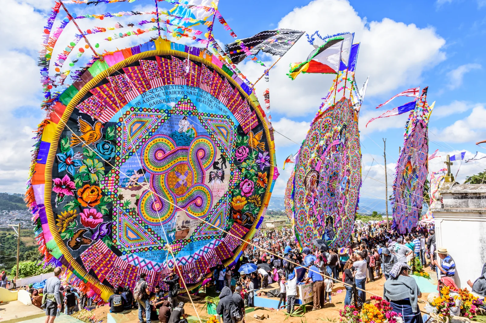 Giant kites rising over the crowd at a Guatemalan Day of the Dead festival