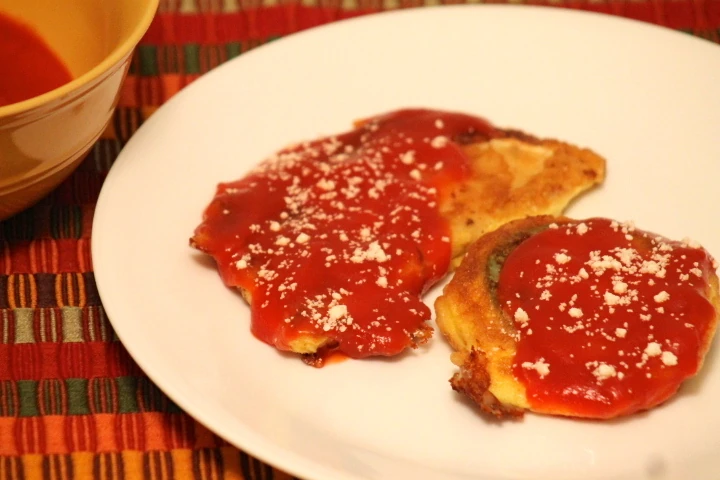 Guatemalan chilaquilas, corn tortillas filled with cheese, battered and fried
