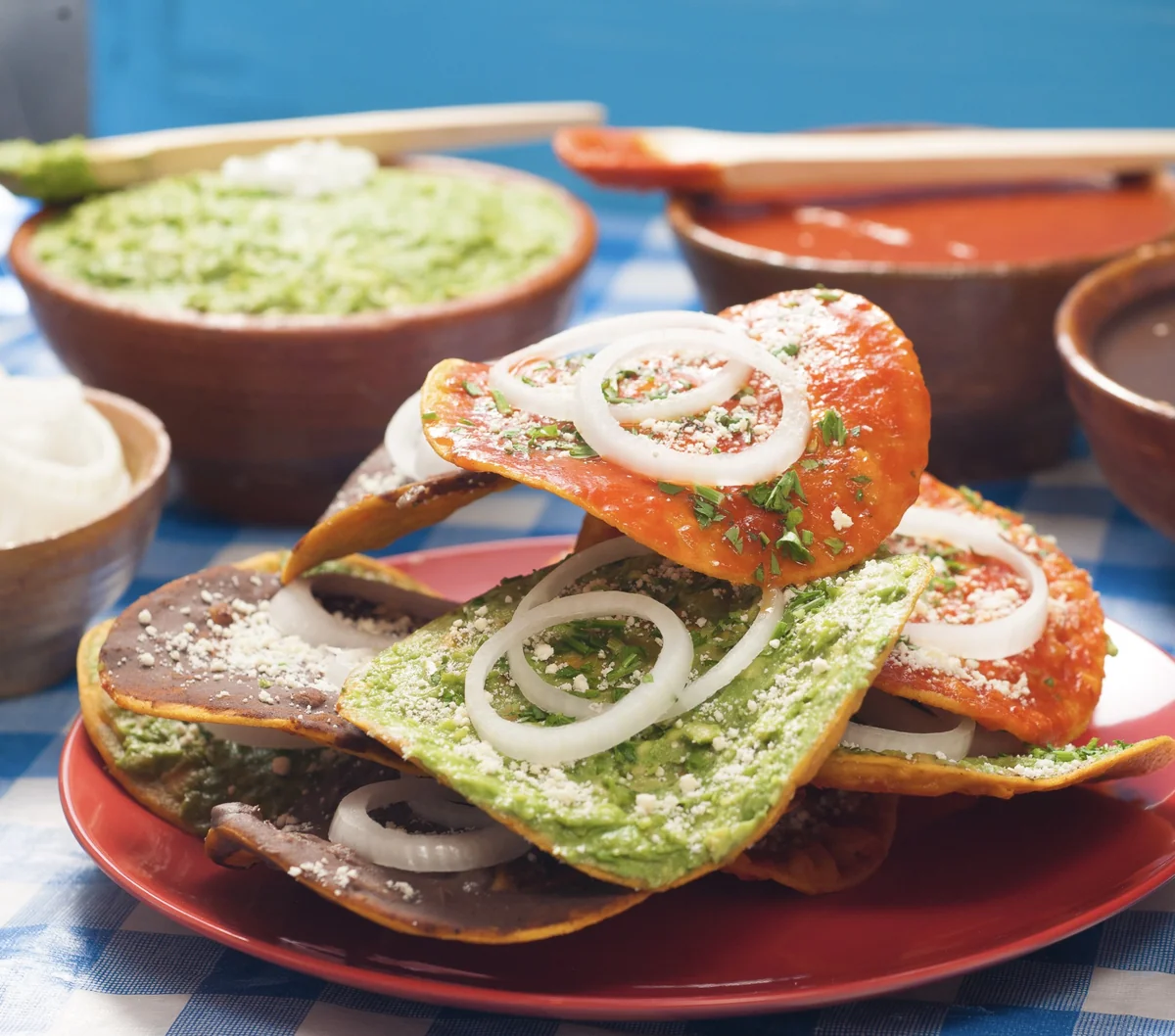 Guatemalan tostadas topped with guacamol, black beans, and tomato sauce