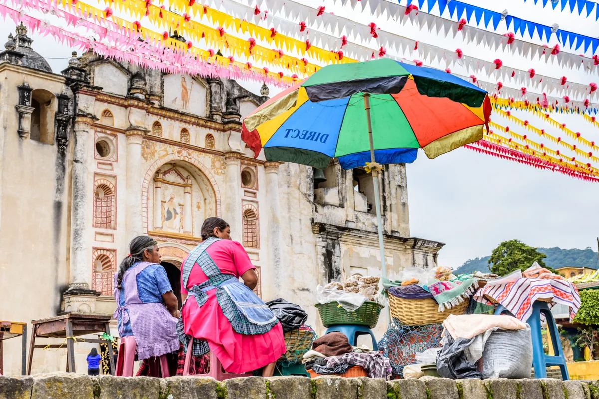 Colorful umbrella and street vendors near a church in Antigua Guatemala