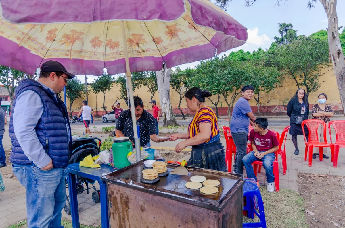 Diners at a covered pupusa street food comedor stall in Antigua Guatemala