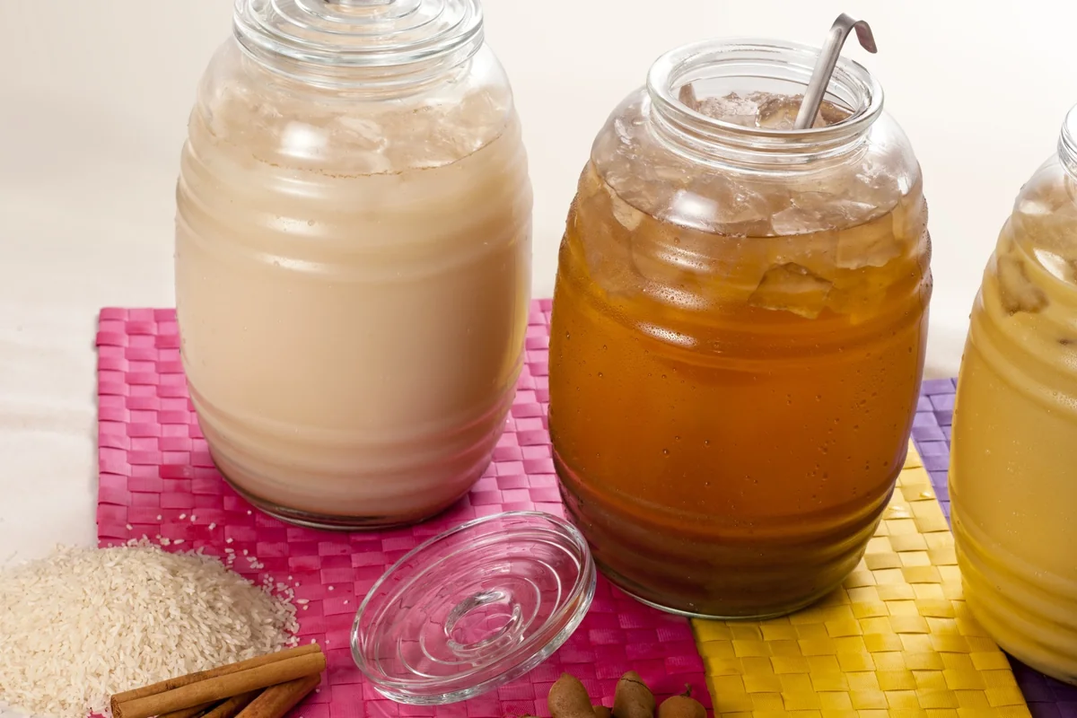 Two jars of Guatemalan street drinks, white horchata and amber agua de tamarindo