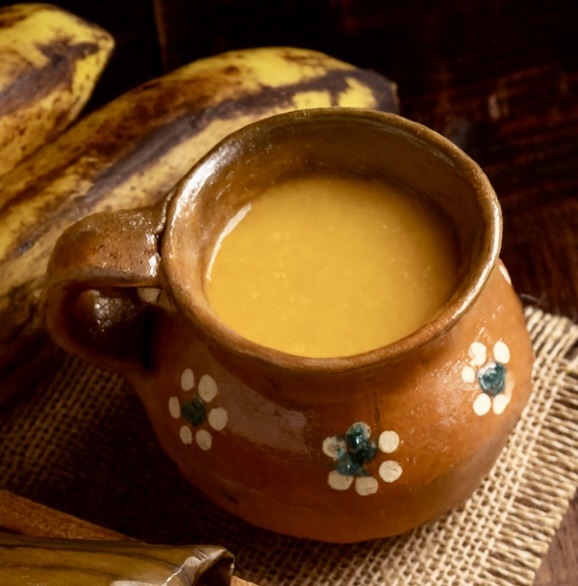 Plantain atole in traditional Guatemalan mug with ripe plantains