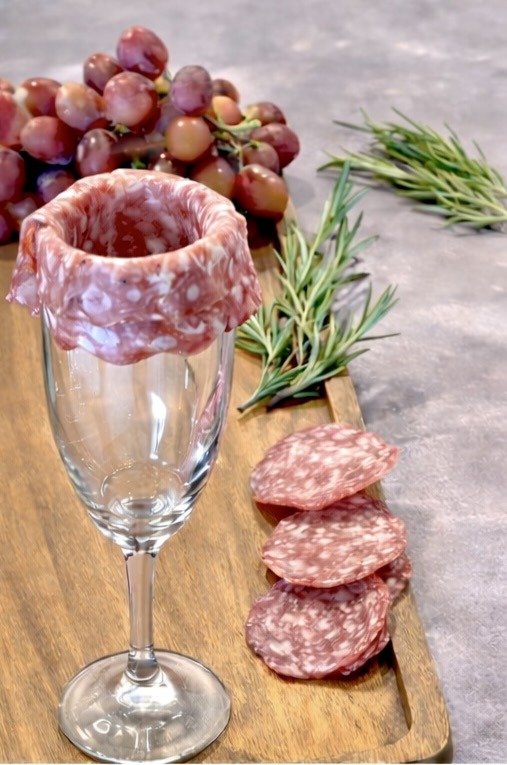 Learn how to make a salami rose using a wine glass for a brie cake charcuterie board or holiday grazing board. This simple technique adds an elegant touch to Christmas charcuterie boards and pairs beautifully with a cranberry brie cake centerpiece.
