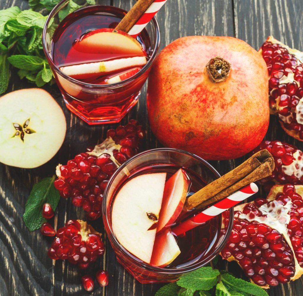 Easy pomegranate apple sangria served in glasses with apple slices and cinnamon, a festive holiday cocktail and Christmas sangria for winter gatherings