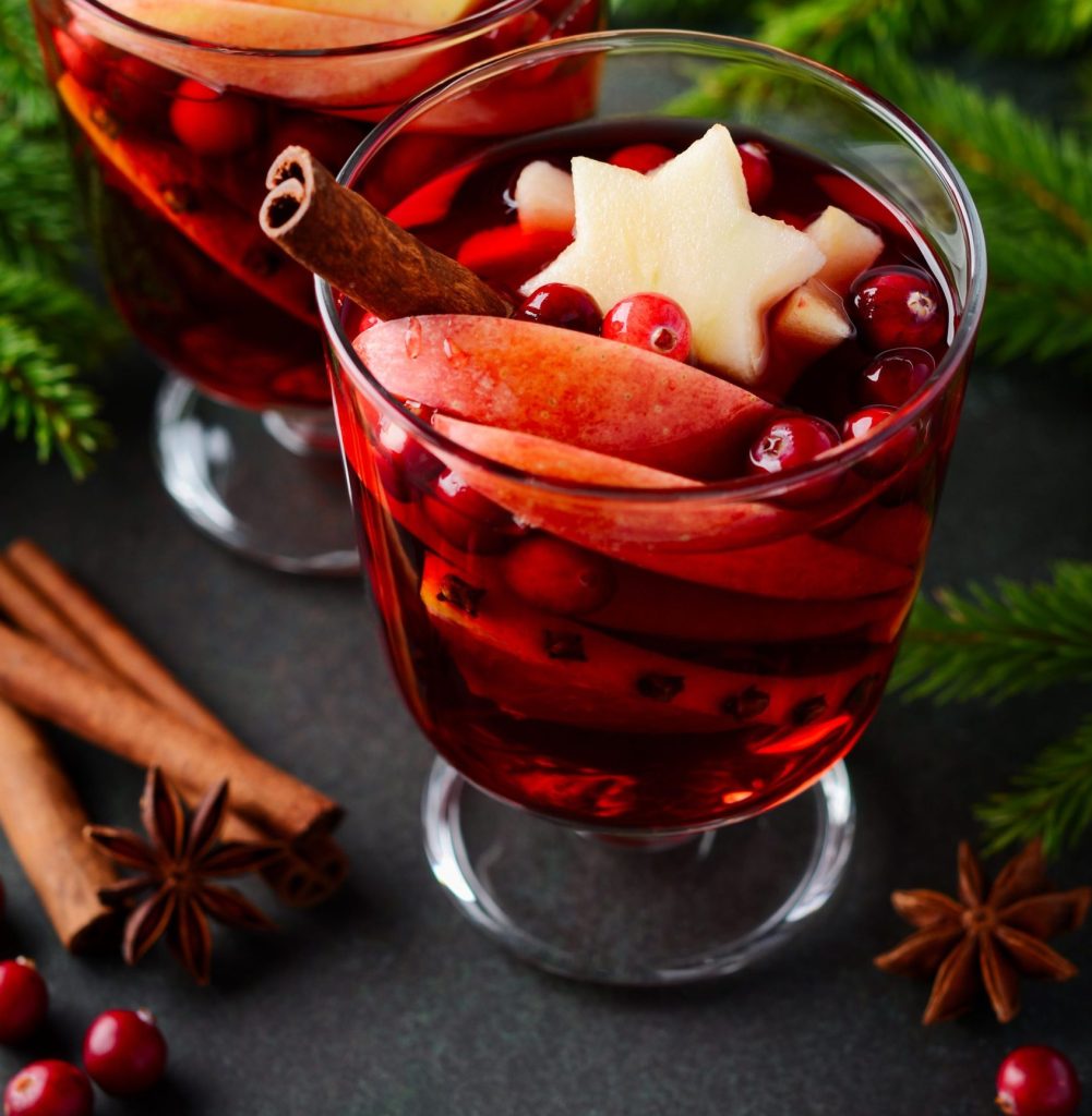 Warm Christmas mulled wine recipe with cranberries, apples, and cinnamon sticks