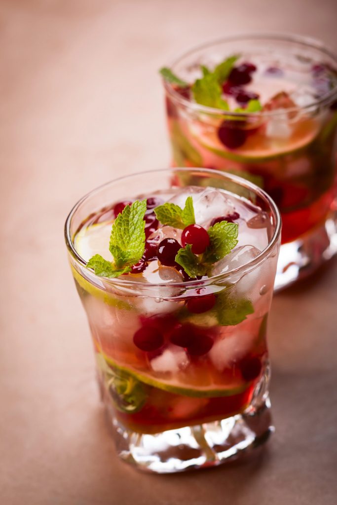 Festive cranberry mojito cocktail recipe with fresh mint, lime, and cranberries over ice.
