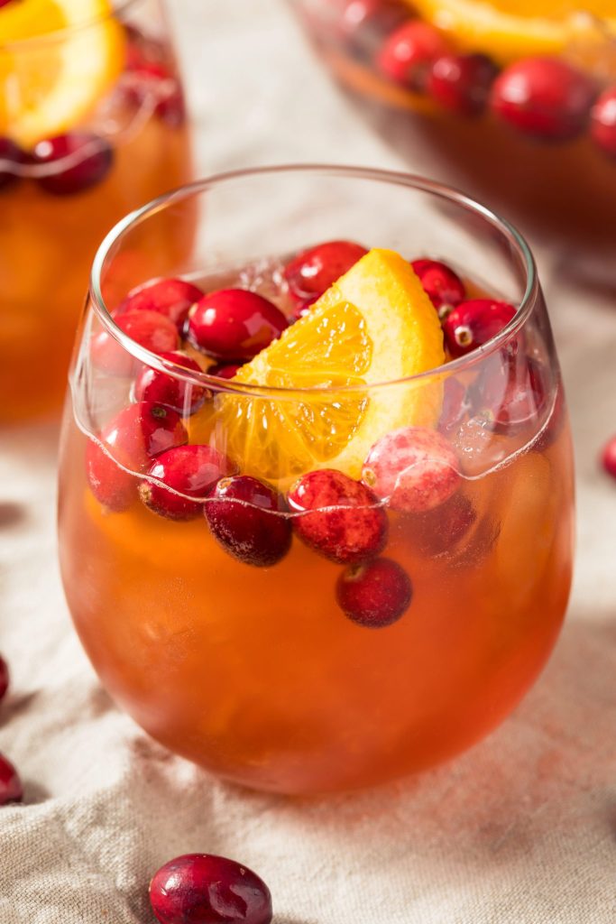 Cranberry champagne punch with orange slice and fresh cranberries in a glass