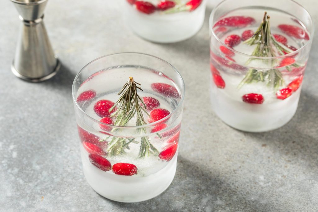 Christmas snow globe cocktail made with a clear rosemary citrus ice base and gin and tonic, an elegant holiday gin cocktail for winter entertaining