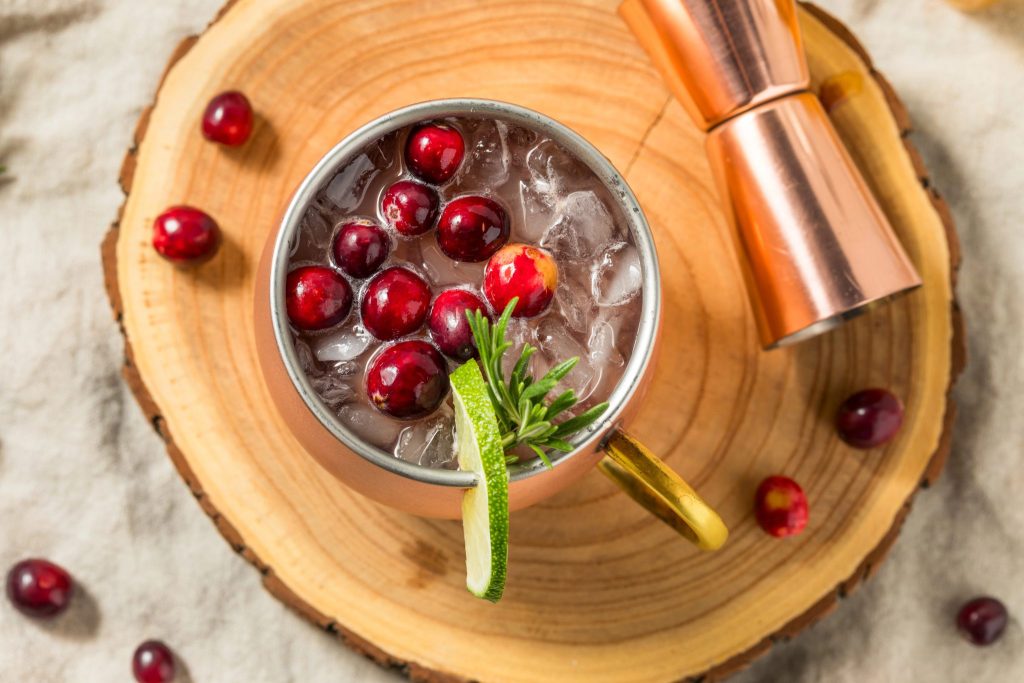 This festive cranberry Moscow mule is a winter vodka cocktail made with ginger beer, fresh cranberries, and lime. A light, bubbly holiday drink that’s easy to make for Christmas.