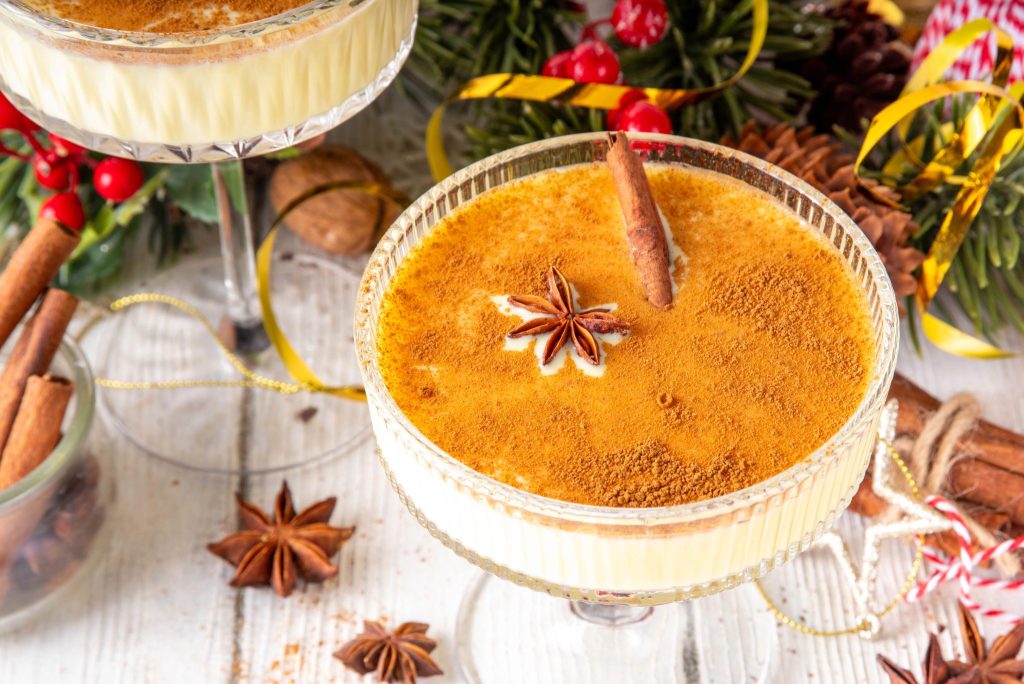 Two eggnog martinis served in coupe glasses with cinnamon garnish